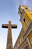 Stone cross at the yellow neoclassical style Cathedral of Granada, Nicaragua