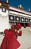 Red robed monks enter the Drepung Monastery Lhasa Tibet