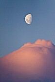 The Lindblad Expedition ship National Geographic Explorer in Dahlman Bay in late evening light as the waxing moon rises on the west side of the Antarctic Peninsula in Antarctica