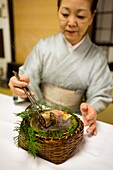 Woman in Kimono cooking traditional Japanese food in a Ryokan on Isu Pennisula in Japan