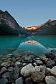 Lake Louise with foreground rocks just after sunrise
