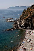 Sunbathers on the beach at Riomaggiore in the Cinque Terre region of the Italian Riviera or Riviera di Levanto