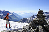 Frau steht vor Steinmann und blickt auf Südtiroler Berge und Dolomiten, Wilder Freiger, Ridnauntal, Stubaier Alpen, Südtirol, Italien