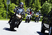 Group of biker driving past car, pass street, Kuehtai, Stubai range, South Tyrol, Italy