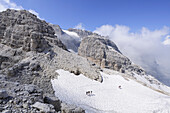 Bergsteigergruppe steigen über Schneefeld auf, Bocchetteweg, Brenta, Dolomiten, UNESCO Weltkulturerbe Dolomiten, Trentino, Italien