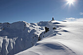 Two skiers on snow cornice, Pischa, Davos, Canton of Grisons, Switzerland