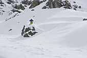 Skifahrer springt über Fels, Arosa, Kanton Graubünden, Schweiz