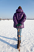 Girl on frozen outer Alster in winter, Hamburg, Germany