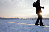 Man sliding over frozen outer Alster, winter, Hamburg, Germany