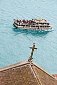 Douro river with tourist boat and church Cross, detail in foreground, Porto, Portugal