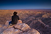 Tourist enjoying a quiet evening overlooking eroded hills of the Borrego Badlands, Fonts Point, Anza Borrego Desert State Park, San Diego County, California