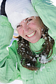Frau mit Schnee im Gesicht lacht, British Columbia, Kanada