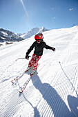 Child downhill skiing on fresh primed ski piste, Schlosslelift, Kleinwalsertal, Vorarlberg, Austria