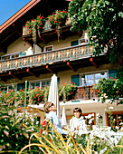 Paar entspannen sich im Gerten, Aussenansicht, Naturhotel Chesa Valisa, Hirschegg, Kleinwalsertal, Österreich