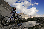 Cyclist Roland Stauder at Paternsattel, view at Zwoelferkofel, Hochpuster valley, South Tyrol, Dolomites, Italy, Europe