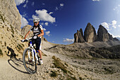 Cyclist Roland Stauder in front of the Drei Zinnen, Hochpuster valley, South Tyrol, Dolomites, Italy, Europe