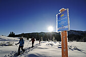 Schneeschuhwanderer und vereistes Schild in Winterlandschaft, Hemmersuppenalm, Reit im Winkl, Bayern, Deutschland, Europa