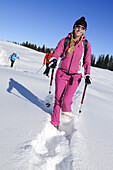 Junge Frau beim Schneeschuhlaufen, Hemmersuppenalm, Reit im Winkl, Bayern, Deutschland, Europa