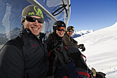 Lachende Skifahrer auf Sessellift, Champatsch, Engadin, Graubünden, Schweiz, Europa