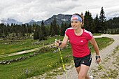 Woman nordic walking at Eggen alp, Reit im Winkl, Bavaria, Germany, Europe