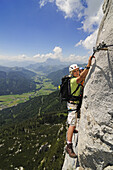 View at couple at rock face, Schuasta Gangl, Gamssteig fixed rope route, Steinplatte, Reit im Winkl, Chiemgau, Upper Bavaria, Bavaria, Germany, Europe