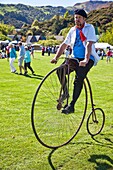 Riding Penny Farthing bicycle, French festival, Akaroa, Banks Peninsula, Canterbury, New Zealand