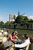 Café on Peniche on River Seine in front of Notre Dame Cathedral, Paris, France