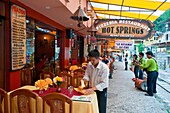 An outdoor restuarant with colorful table setting and entertainers in Agua Calientes, Peru