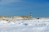 Wide angle view of lighthouse List East on snow covered dunes with a bright blue sky at a sunny day, Sylt, Northfrisian Islands, Schleswig-Holstein, Northern Germany, Europe
