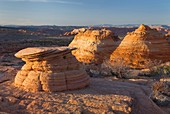 Setting sun illuminating cross-bedding in sandstone buttes of South Coyote Buttes, Vermilion Cliffs Wilderness Utah