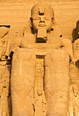 closeup of the pharaoh Ramses at the sun temple of Abu Simbel lit up in early morning sunlight in Upper Egypt