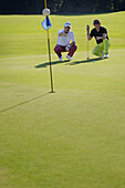 Two men playing golf, Prien am Chiemsee, Bavaria, Germany