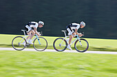 Two racing cyclists on road near Munsing, Upper Bavaria, Germany