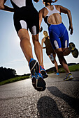 Three runners on road near Munsing, Upper Bavaria, Germany