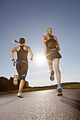 Two female runners on road near Munsing, Upper Bavaria, Germany