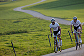 Two racing cyclists on road near Munsing, Upper Bavaria, Germany
