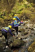 Young children walking in the River Arran near Dolgellau as part of a course organised by the Canolfan Yr Urdd outward bound adventure centre, Glanllyn, Bala, North Wales UK