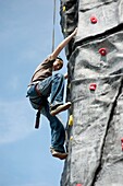 Young teenage boy climbing on a Mobile climbing wall tower at Aberystwyth Leisure Centre, Wales UK