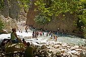 Tourists wade mountain stream in Saklikent gorge South West Turkey