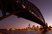 The Sydney skyline at sunset framed by the Harbour Bridge from North Sydney