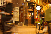 Street scene at night with cyclist in the old town of Amsterdam, Netherlands