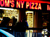 Neon sign in front of a pizza restaurant at night, Miami, Florida, USA