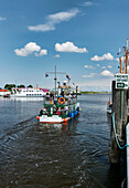 Boat leaving the harbour at Greetsiel, East Frisia, Lower Saxony, Germany