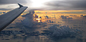 Blick aus dem Flugzeug während eines Fluges auf eine Inselgruppe unter den Wolken