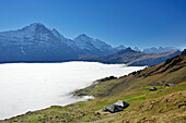 Alpine huts in front of Eiger, Moench and Jungfrau with sea of fog above Grindelwald, Bussalp, Grindelwald, UNESCO World Heritage Site Swiss Alps Jungfrau - Aletsch, Bernese Oberland, Bern, Switzerland, Europe