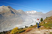 Woman hiking on track above glacier Grosser Aletschgletscher, Grosser Aletschgletscher, UNESCO World Heritage Site Swiss Alps Jungfrau - Aletsch, Bernese Alps, Valais, Switzerland, Europe