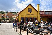 People in front of herring smokehouse with restaurant, Gudhjem village, Bornholm, Denmark, Europe