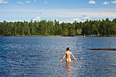 Frau badet nackt in Boasjön See, Smaland, Schweden