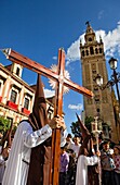 Penitents and Giralda.Calle Argote de Molina. Holy Week procession ,  El Carmen Doloroso,  Holy Wednesday Seville Spain