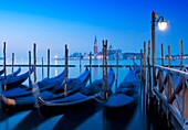 Gondola moorings at night before dawn beside Grand Canal at San Marco in Venice Italy